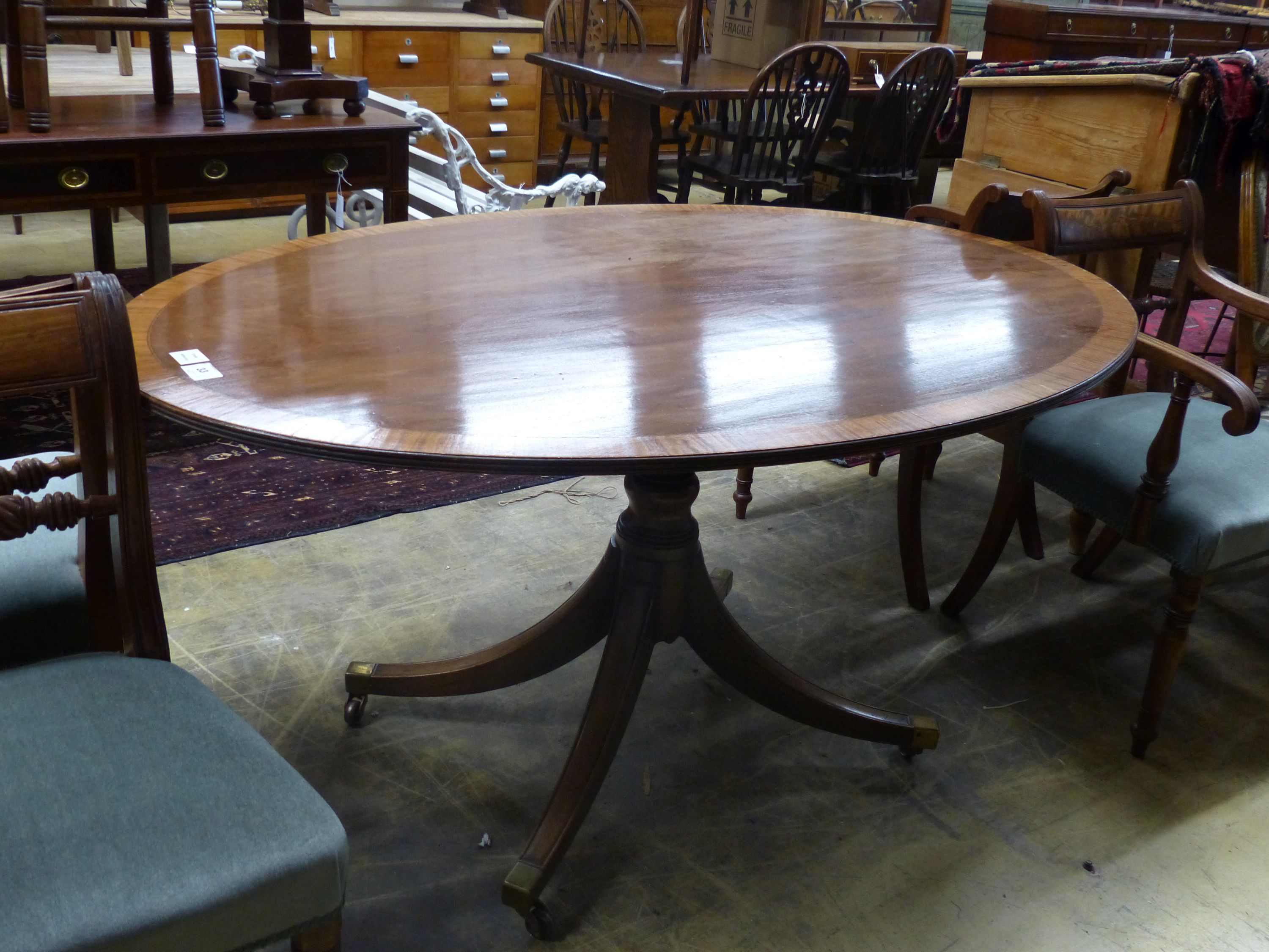A Regency style oval banded mahogany dining table, length 150cm, depth 103cm, height 76cm